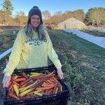 Diane Dorfer holding a crate of rainbow carrots